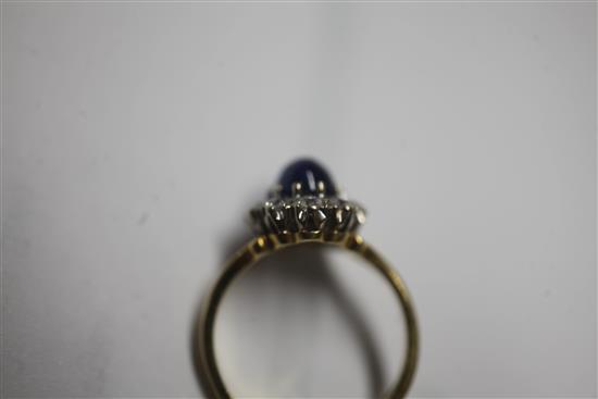 A cabochon sapphire and diamond cluster ring, size N.
